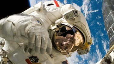 An astronaut working in space with the Earth in the background